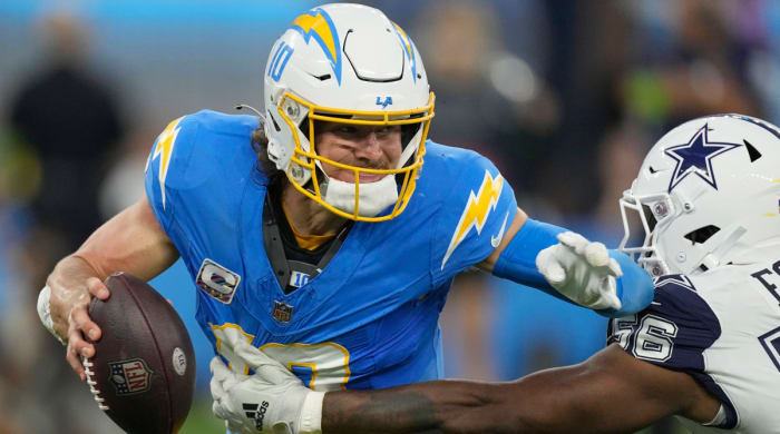 Chargers quarterback Justin Herbert attempts to evade a tackle by Cowboys defensive end Dante Fowler Jr.